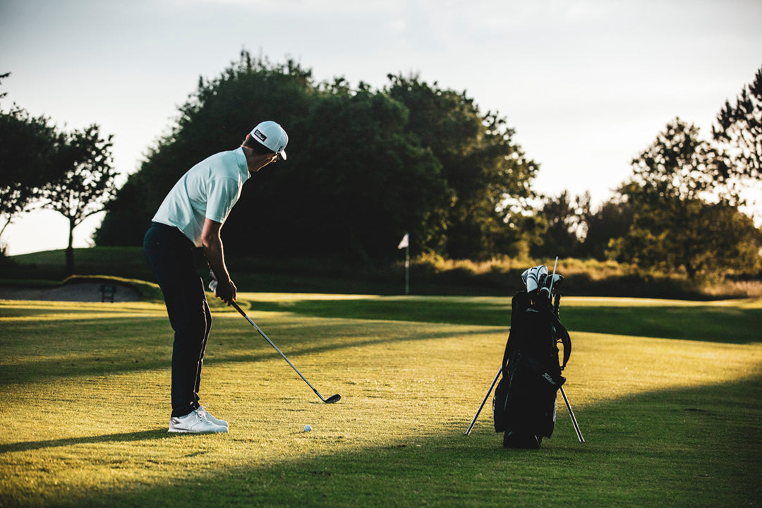 Golfer on a golf course with trees in the background